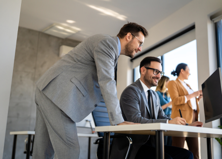Due professinisti in abiti formali lavorano insieme davanti al pc