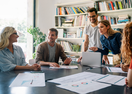 Gruppo di professionisti commenta delle slide stampate attorno alla scrivania