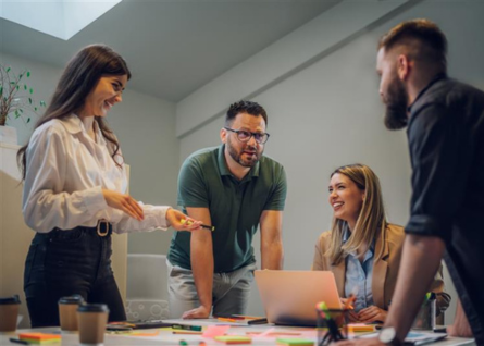 Quattro giovani professionisti, due donne e due uomini, discutono insieme un progetto