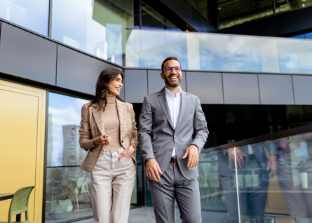 Una donna e un uomo camminano parlando in modo cordiale di business