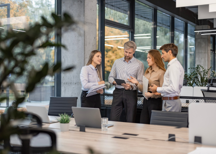 Gruppo di professionisti, due donne e due uomini, collaborano all'interno di un open space
