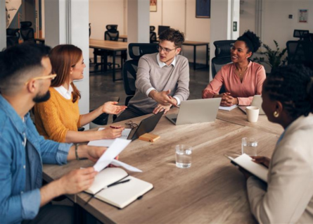 Gruppo di lavoro intorno a un tavolo di legno collabora attivamente