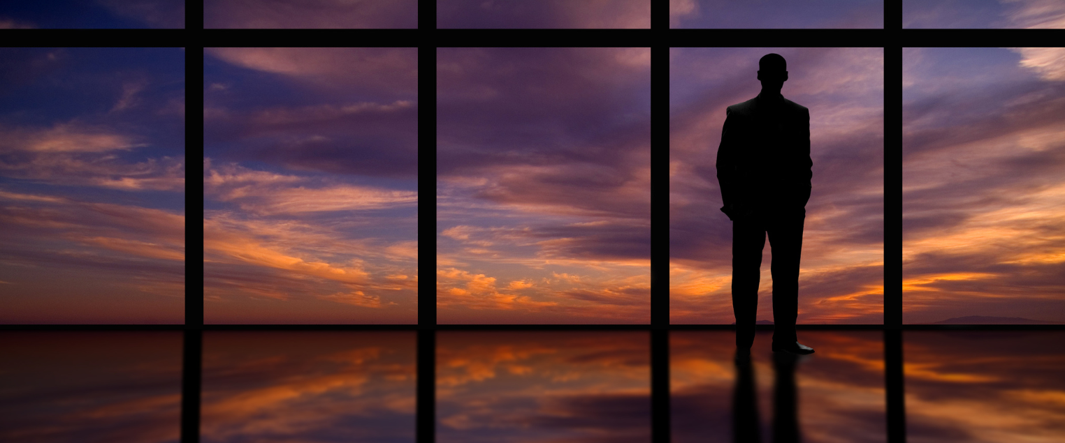 uomo che guarda tramonto fuori dalla finestra