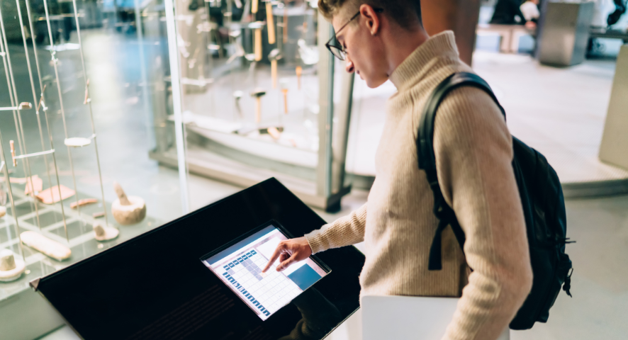 Ragazzo in un museo consulta la guida digitale su schermo