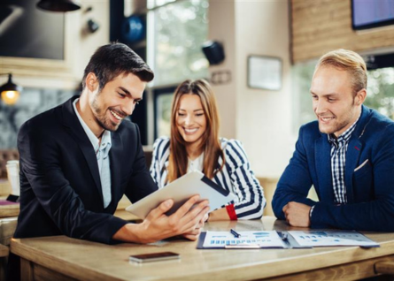 Tre professionisti, due uomini e una donna. osservano concentrati un tablet
