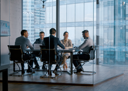 Gruppo di cinque professionisti è in riunione in una sala vetrata