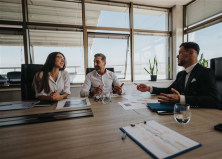 Due professionisti, una donna e un uomo, sono in una riunione di lavoro con un altro uomo