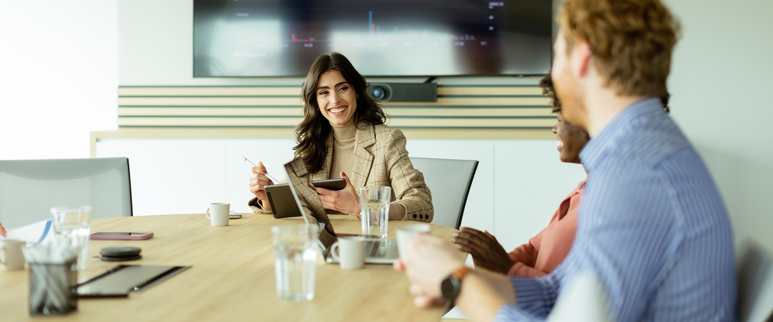 Giovane professionista lavora con collega, sullo sfondo un grafico con una linea di crescita